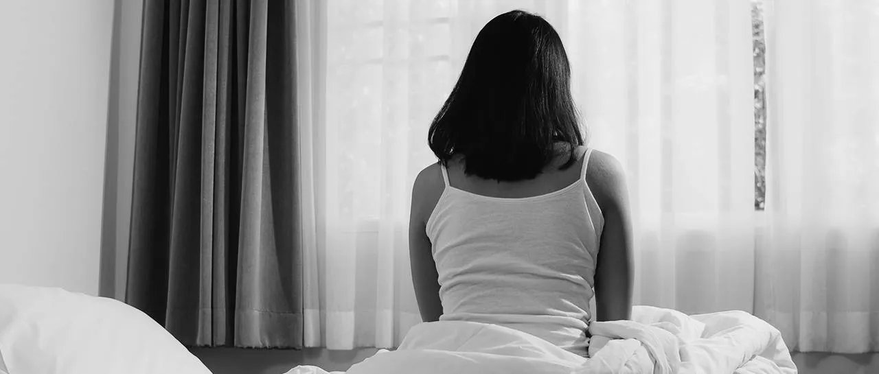 mulher sentada na cama com hiperglicemia